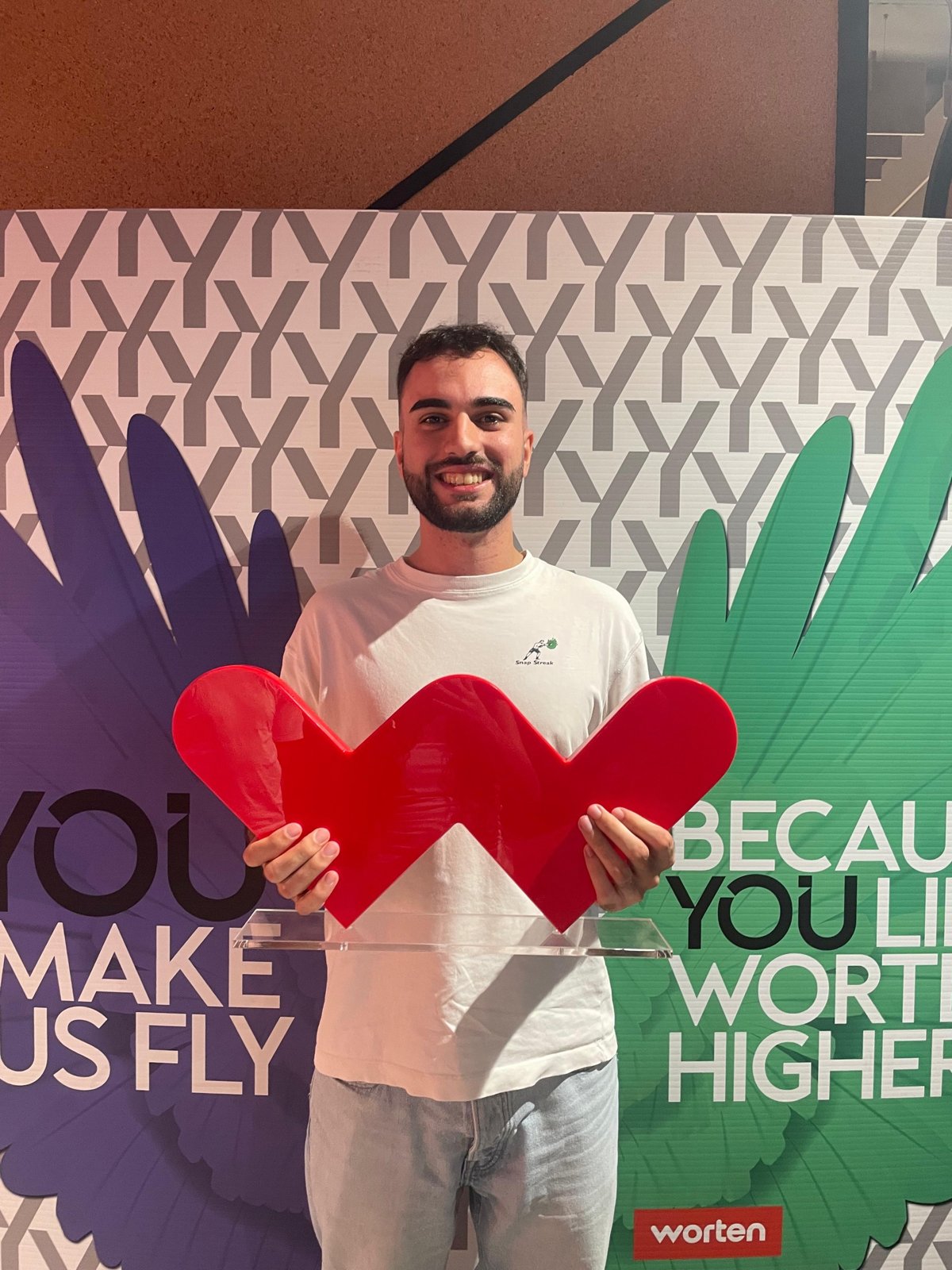 Leonardo at a Worten event holding the Worten heart logo